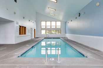 a large indoor swimming pool in a large room with a large window